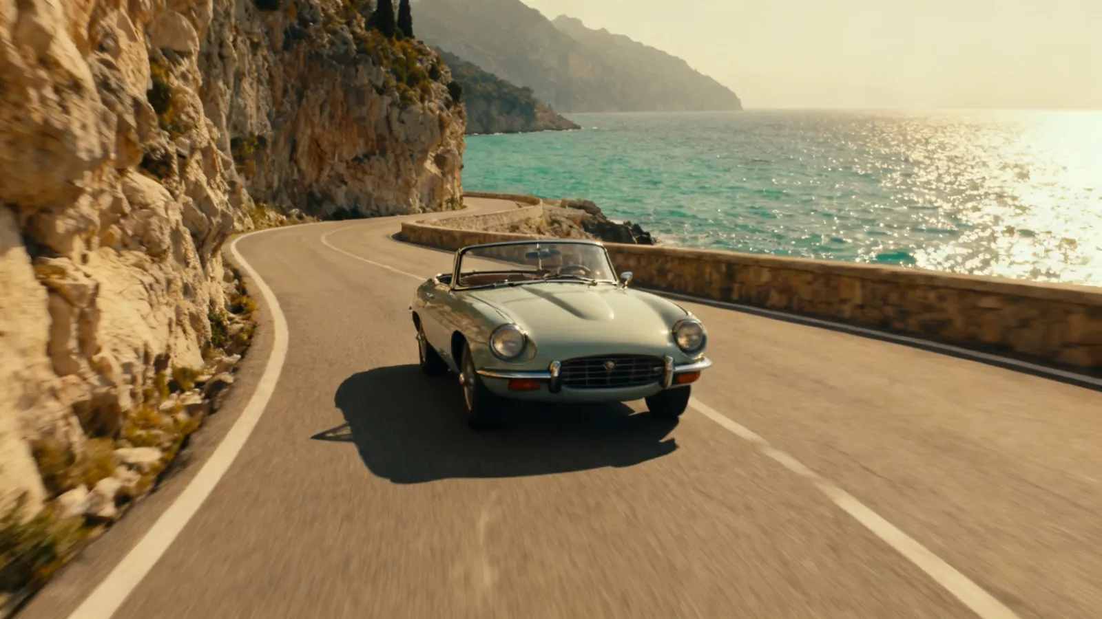 Vintage convertible on a coastal road at golden hour