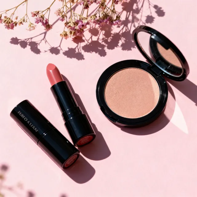 Lipsticks and a compact on blush pink