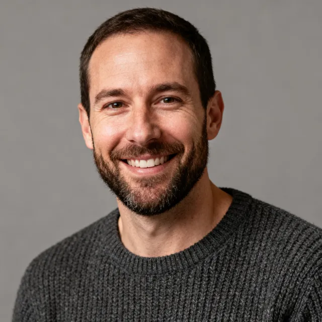Studio headshot of a smiling man
